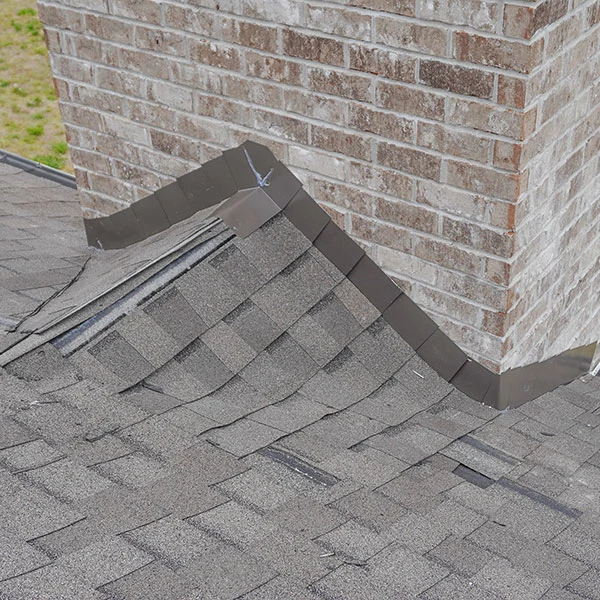 Shingle-covered chimney cricket with closed valleys and dark flashing